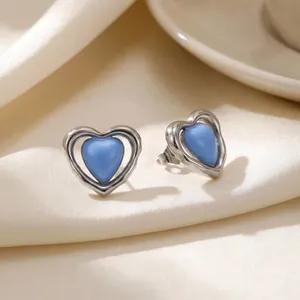 Vista detallada de pendientes de corazón de acero inoxidable con centros de resina azul