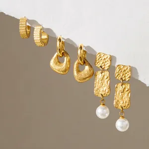 Detalle de pendientes chapados en oro con acabado martillado vintage y perlas