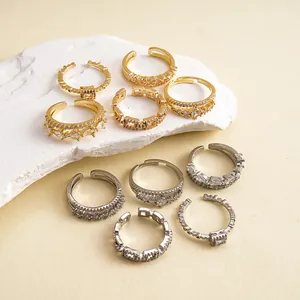 Vue détaillée de dessus de diverses bagues en zircon or et argent sur un socle en pierre.