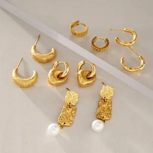 Vista macro de pendientes vintage dorados con texturas martilladas y perlas blancas
