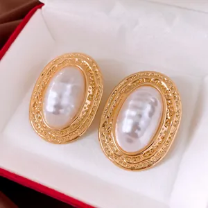 Detailansicht der ovalen Perlenohrringe im Vintage-Stil mit strukturiertem Goldrahmen.