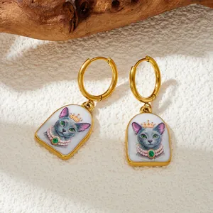 Détail des boucles d'oreilles vintage avec un motif de chat peint à la main