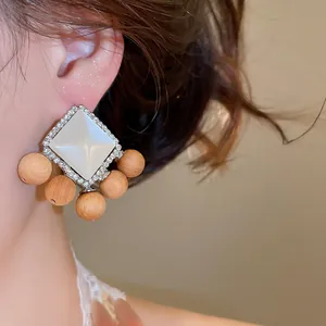Vue détaillée de boucles d'oreilles rétro ethniques avec résine, strass et perles en bois