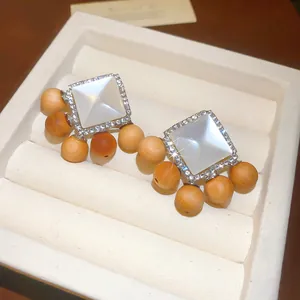 Gros plan de boucles d'oreilles vintage en résine avec perles en bois et strass