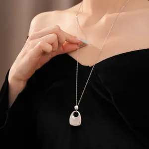 Detailansicht einer minimalistischen silbernen Halskette mit unregelmäßigem Anhänger.