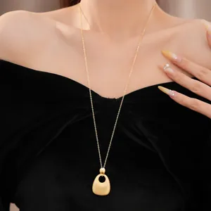 Elegante goldene Halskette mit Tropfenanhänger auf einem schwarzen Samtoberteil
