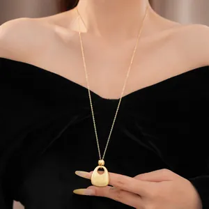 Detailansicht einer eleganten goldfarbenen Halskette mit rundem Faltenanhänger auf Samt