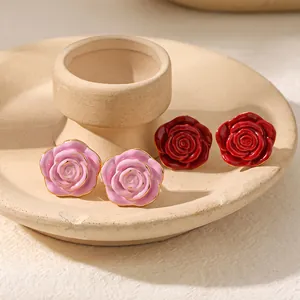 Close-up detail of rose flower enamel earrings in pink and red with 18k gold plating