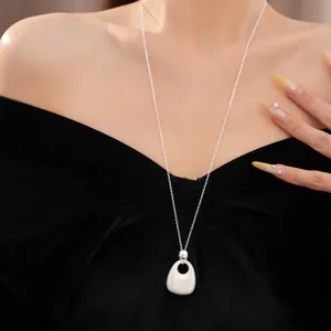 Nahaufnahme einer minimalistischen silbernen Metall-Halskette an einem Model in Samt.