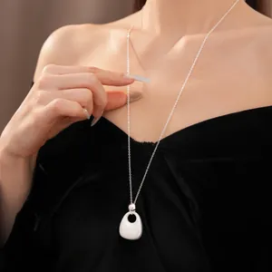 Minimalistische silberne Halskette mit hohlem Tropfenanhänger für einen schicken Lagen-Look.