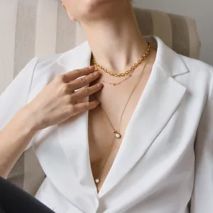 Detail shot of layered 18k gold plated stainless steel necklaces with pearls and zirconia.