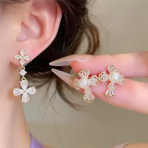Détail macro montrant des boucles d'oreilles fleur en zircon plaqué or 18 carats et perles