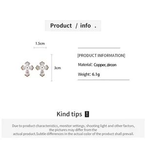 Vue détaillée de boucles d'oreilles croix plaquées or 18k avec zircon et perles.