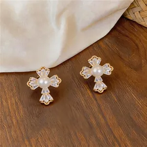 Vue détaillée des boucles d'oreilles fleurs en zircon plaqué or 18k avec perle centrale.