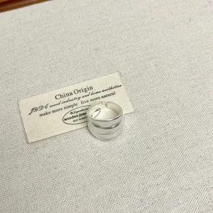 Gedetailleerde macro-opname van een matzilveren brede ring met vintage hamerslag