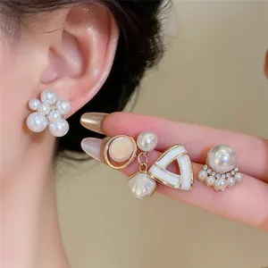 Gros plan sur des boucles d'oreilles en perles vintage françaises avec détails dorés