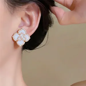 Boucle d'oreille perle de style français portée à l'oreille, aux détails vintage délicats.