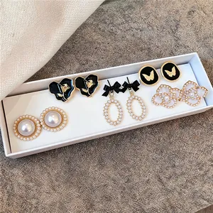 Vue détaillée d'un ensemble de boucles d'oreilles vintage en perles et émail chic