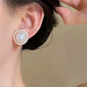 Vue détaillée de boucles d'oreilles élégantes en perles rondes de style français sur un modèle