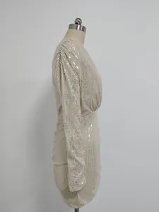 Side view of sequin mini dress with long sleeves and pleated details