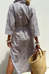 Rear view of three-quarter sleeve patterned shirt dress with side slit and belt