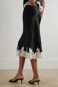 Elegant black satin midi skirt with white lace hem, part of a two-piece loungewear set