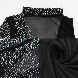 Dettaglio di body in rete nera con strass luccicanti e texture del tessuto morbida.