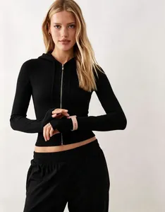 Dettaglio di un completo con felpa nera a coste con zip e cappuccio e pantaloni