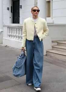 Ganzkörper-Streetstyle einer schicken cremefarbenen Tweedjacke mit weiten Jeans
