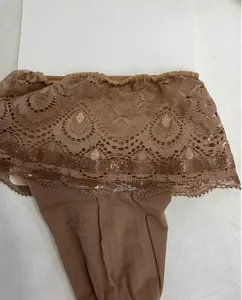 Detailansicht brauner Halterloser Strümpfe mit Silikonband und Spitze mit Pfauenmuster.