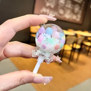 Detail of a lollipop shaker charm with colorful beads and snowflakes in liquid oil.