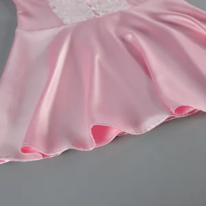 Detailed macro shot of the pink satin fabric and lace trim on a summer dress.