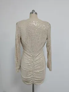 Back view of a champagne sequin ruched long-sleeved evening dress on a mannequin
