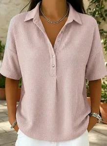 Gros plan d'un polo rose en maille gaufrée avec col boutonné et manches courtes