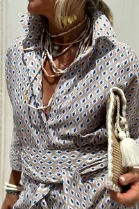 Close-up detail of bohemian patterned shirt dress featuring lapel and accessorized necklaces