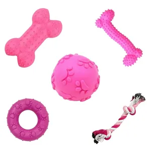 Close-up detail of five pink dog chew toys including rope knot and paw-print ball