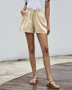Detalle de pantalones cortos de lino tipo evasé en color beige para mujer en verano.