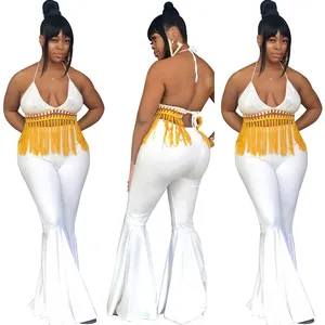Detalle de los pantalones de campana blancos y el top de ganchillo con flecos sexy