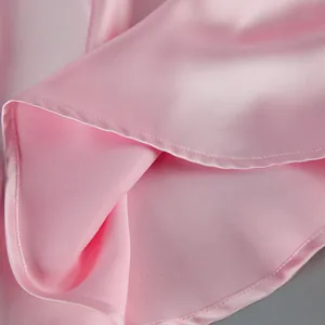 Macro shot of pink satin dress fabric showing smooth texture and neat stitching detail