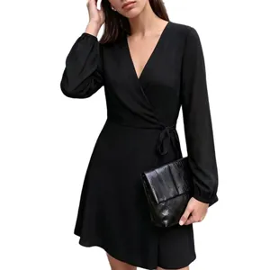 Elegante vestido cruzado negro con cuello en V, mangas abullonadas y cinturón de lazo