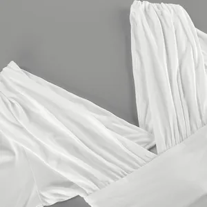 Primer plano detallado de top blanco de modal con cuello en V y pliegues elegantes.