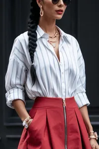 Detail shot of a women's blue and white striped shirt paired with a red skirt