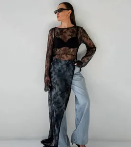 Vue détaillée de la robe en dentelle noire transparente avec fente asymétrique.