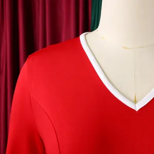 Detail of a red professional dress showing the white V-neckline and smooth fabric texture