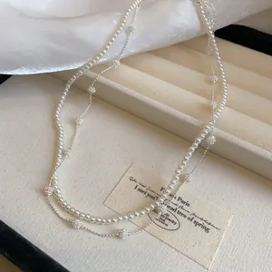 Detail view of a double-layered vintage French style pearl necklace with silver accents