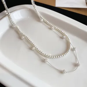 Detailed view of a double-layered necklace with pearls and textured silver beads on a tray.