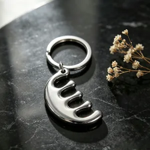 Close-up detail of a minimalist silver stainless steel comb-shaped keychain pendant