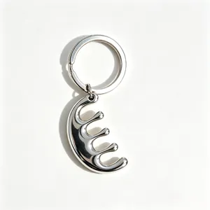 Close-up macro detail of a minimalist silver stainless steel comb-shaped keychain pendant