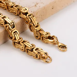 Makro-Detailansicht eines klobigen goldenen Byzantiner-Gliederkettenarmbands aus Edelstahl