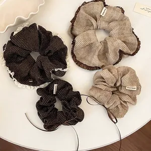Set of four retro polka dot fabric scrunchies in brown and beige with ruffles